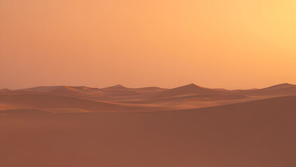 Serene desert landscape with sand dunes under a warm orange sky at sunset