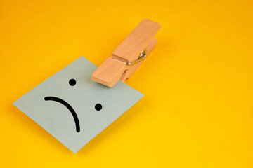 Clothespin holding a sad face note as an office reminder of Blue Monday, highlighting awareness, empathy and available support resources.
