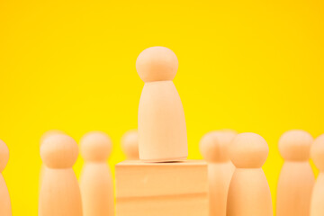 figure elevated above a group to illustrate leadership, authority, and recognition.
