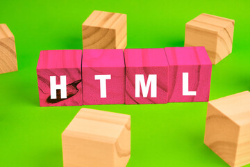 HTML coding concept with blocks forming the acronym beside scattered cubes, representing web development foundations and digital structure.
