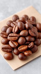 Rustic Flat Lay of Roasted Coffee Beans Scattered on Kraft Paper with Subtle Dusting and Textured Gray Background
