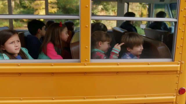 Elementary school children riding a yellow bus