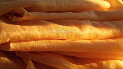 a stack of light yellow fabric under a ray of sunlight
