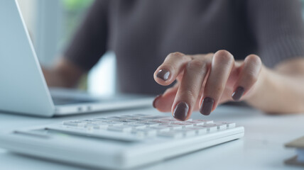 Business woman using calculator to calculate financial report, bookkeeping payroll and budget tax....