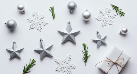 Obraz premium Elegant Silver Christmas Ornaments Stars Snowflakes and Gift Box Flat Lay on White Background