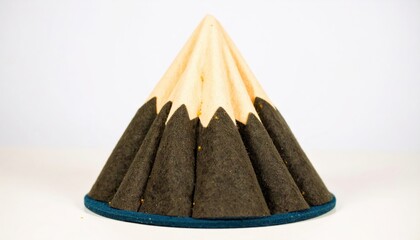 A cone shaped object with a brown base and a light yellow top section.