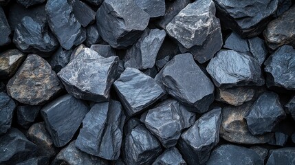 Close-up shot of a pile of rough-hewn dark gray and brownish rocks, texture visible