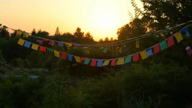 Colorful tibetan prayer flags waving at sunset