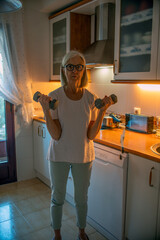 Senior Woman Lifting Dumbbells in Kitchen for Home Fitness and Healthy Lifestyle Improvement