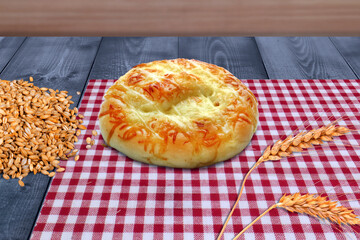 Freshly Baked Round Cheese Bread with Wheat on Checkered Cloth