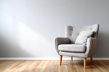 A modern upholstered armchair with a pillow rests on a wooden floor.