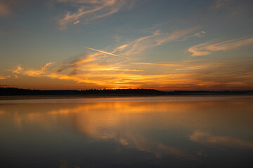 Golden sunrise reflecting over calm lake waters