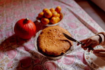 Child cutting homemade cake on patterned tablecloth