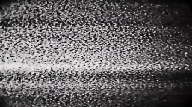 Extreme close-up video of abstract monochromatic television static, dense blizzard of flickering pixels, grainy texture, CRT effect, emulating a no signal broadcast. Unsettling retro visual
