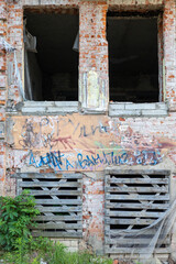 Grunge brick wall with graffiti and broken windows