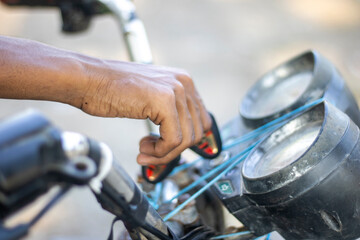 Closeup of a hand starting a motorcycle with a kickstart lever