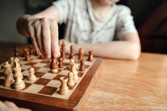 Close-up of boy&rsquo;s hand moving a chess piece.
