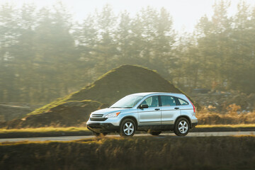 Fototapeta premium SUV journey along country road at golden hour