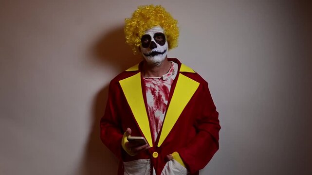 Scary skull clown using a smartphone for halloween