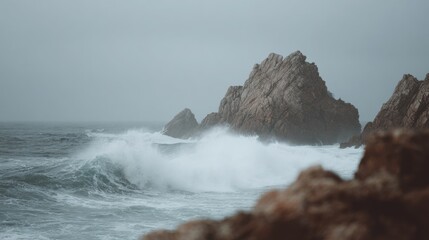 Rocky coastline with a large rock formation in the background.