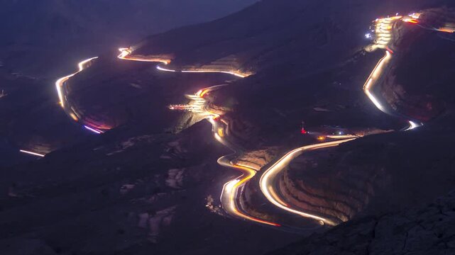 Time lapse of light car traffic moving at night on the road at Jable Jai, Ras Al Khaimah, United Arab Emirates.