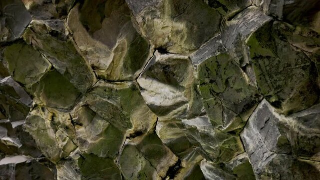 Close up of hexagonal basalt rock formations with moss texture