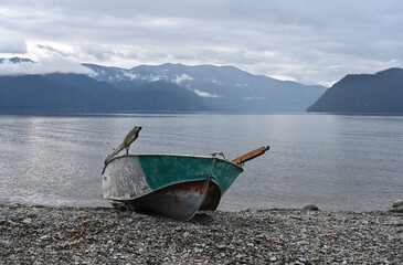 A delightful landscape with a rowing boat on the shore of a mountain lake