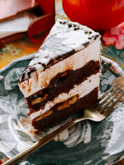 Delicious chocolate cake slice served on a floral plate with a fork nearby