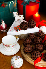 Christmas or New Year sponge cakes cones with holiday gifts, red candle, christmas tree toys and red ribbons