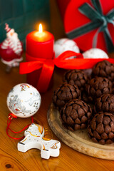 Christmas or New Year sponge cakes cones with holiday gifts, red candle, christmas tree toys and red ribbons