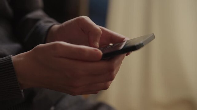 Side view of woman holding using modern smartphone, with fingers scrolling through screen, representing digital communication, internet connectivity, and mobile device usage in daily life, close-up.