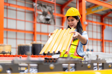 asian engineer worker woman in safety vest and helmet check material with blueprint, people working...