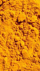Macro close up turmeric powder surface showing natural spice texture and organic detail