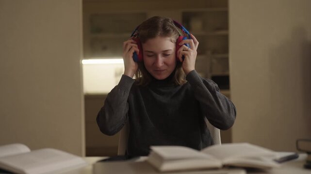 Young woman with cerebral palsy connecting headphones, staying focused during online study session at home, embracing accessible education despite physical disability challenges, portrait, slow motion