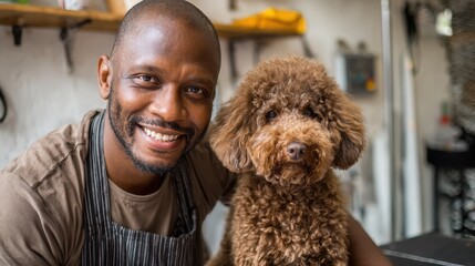 Joyful Black groomer posing with a brown poodle in a pet salon stock photo