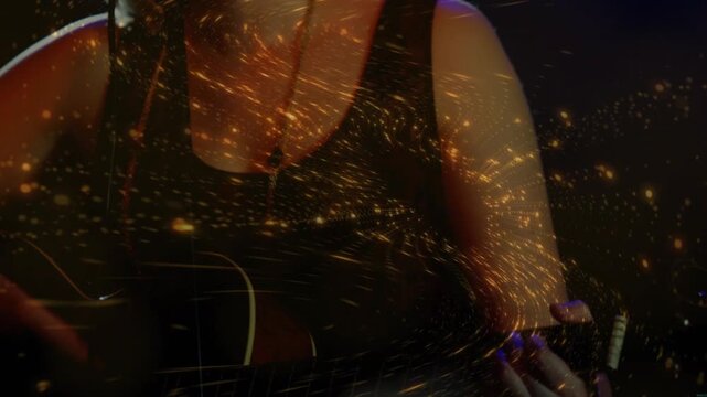 Female music artist strumming guitar, emitting golden particles swirling singing into microphone