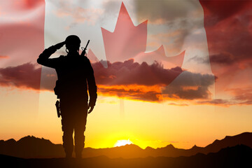 Obraz premium Silhouette of a soldier with Canada flag against the sunset. Armed Forces of Canada