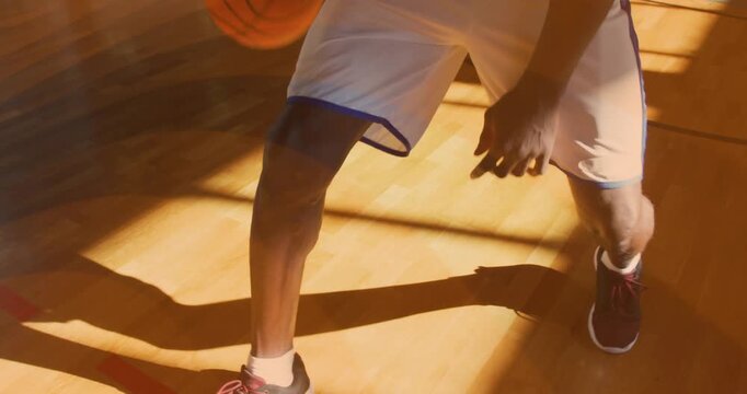 Player bouncing basketball dribbling between-legs move and resuming drill on court for training