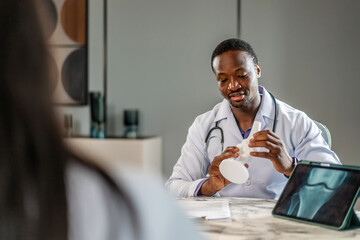 Cheerful doctor and young woman discuss her X-ray from a knee boneresults on a tablet computer. A man analyzes an MRI image to make a diagnosis for a patient, Female consulting trauma surgeon