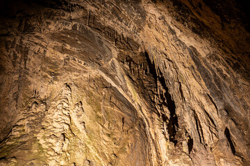 A large rock formation with a lot of texture and detail. Scene is one of awe and wonder, as the viewer is taken aback by the sheer size and complexity of the rock formation
