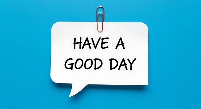 A white speech bubble shaped sticky note with the handwritten message have a good day attached to a bright blue wall with a red paperclip