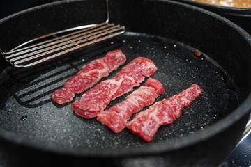 Raw Beef Strips Sizzling on a Grill Pan