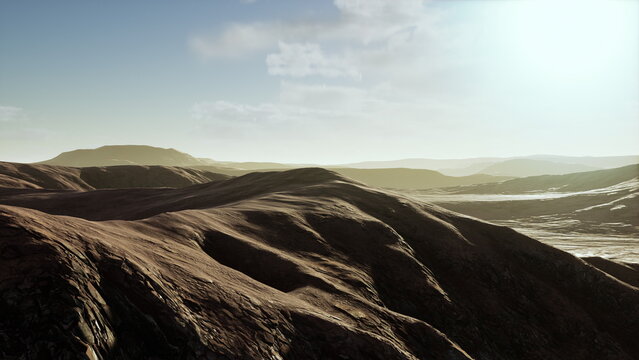 Soft hills stretch across the horizon, illuminated by the warm glow of the setting sun. The tranquil scene invites reflection and appreciation of natures beauty.