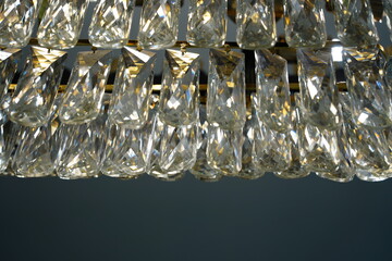 Close-up view of sparkling crystal elements and prisms on a luxurious chandelier, providing an elegant background or texture.
