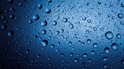Close up View of Numerous Water Droplets on a Dark Blue Surface with Varying Sizes and Reflective Highlights Forming an Abstract Pattern