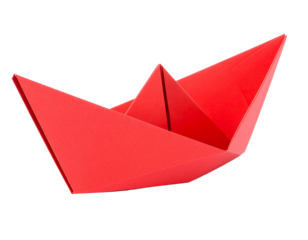 A red paper boat sailing on a smooth surface, casting