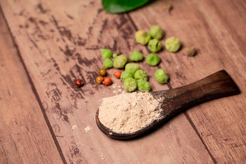 Withania somnifera ( Ashwagandha) Root powder, Green Fruit, green leaves on wooden background. Herb