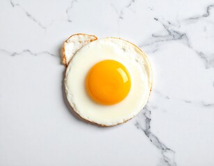 Overhead shot of a sunny-side-up egg on a white surface