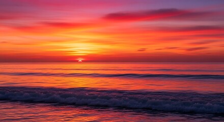 Obraz premium Vibrant sunset over ocean waves painting the sky with fiery colors.