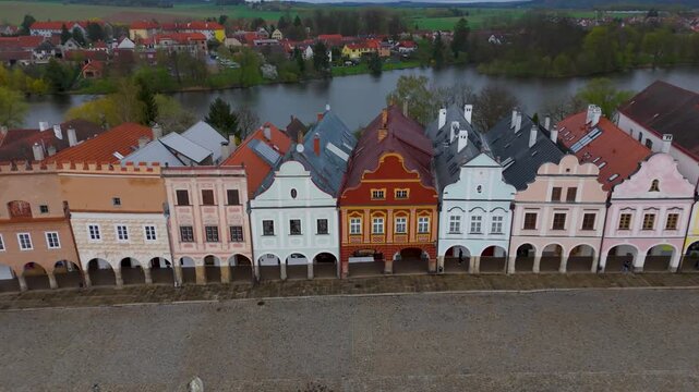 Drone flyover showcasing the UNESCO Telč historic center, focusing on the iconic colorful gabled facades and arcades of the Italian Renaissance houses of Zacharias of Hradec Square, Czech Republic.